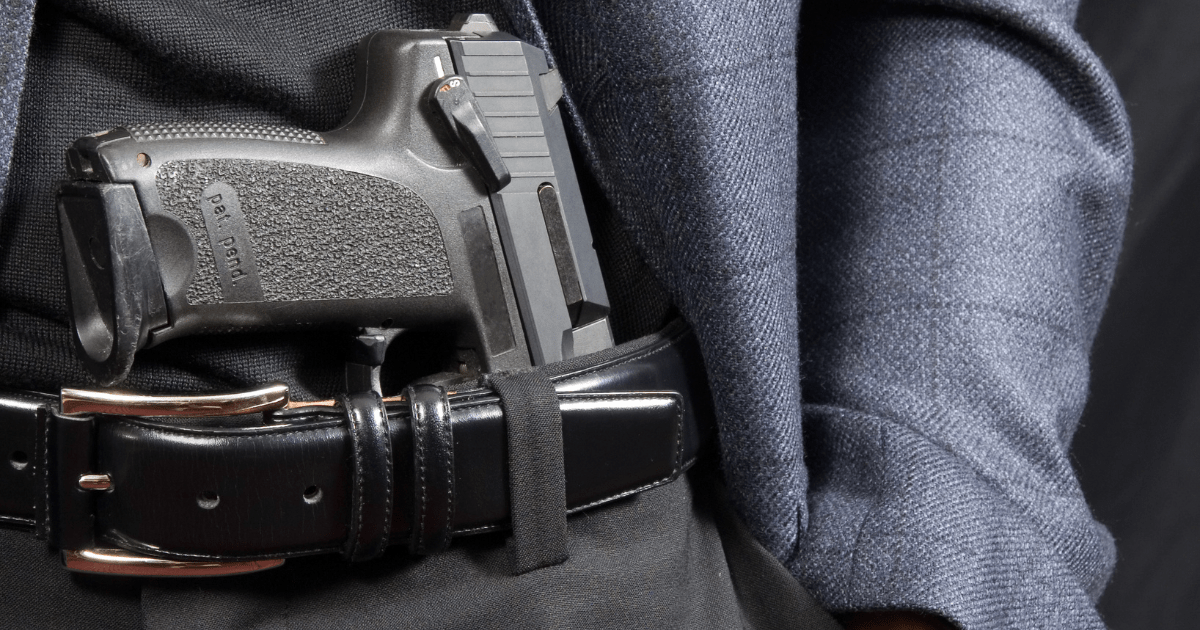 A man wearing a black sports coat with a Glock 19 for everyday carry.