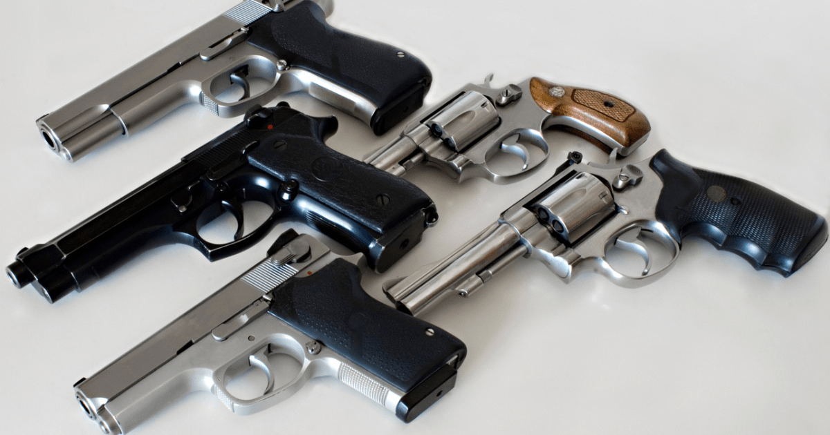 Several different handguns for women on a white table.