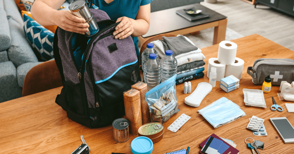 A woman packing her go bag with supplies from her checklist.