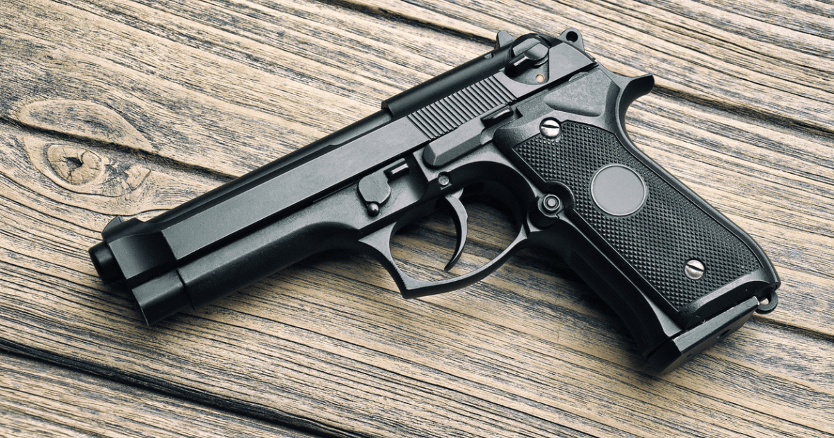 A full size handgun laying on a table.