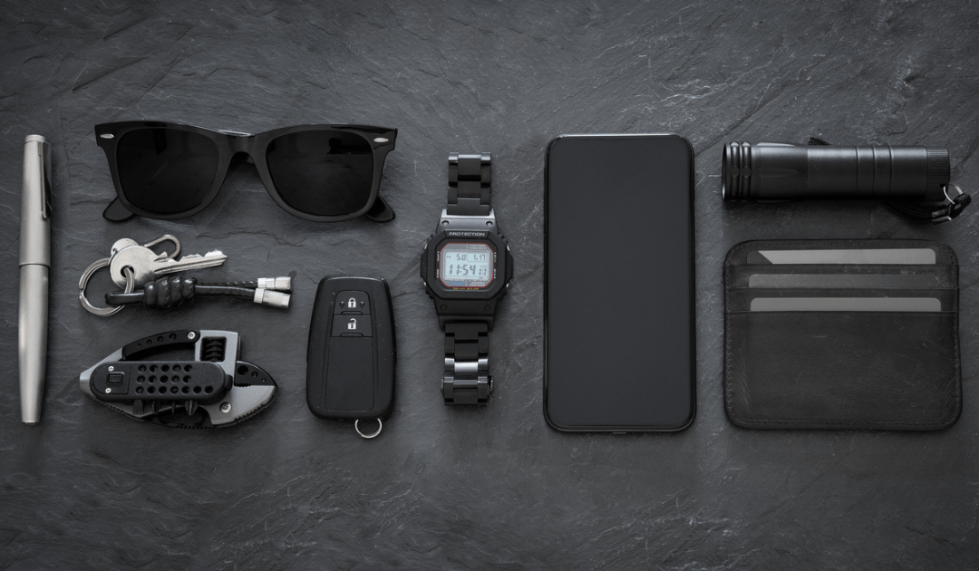 Everyday carry items layed out on a black table.