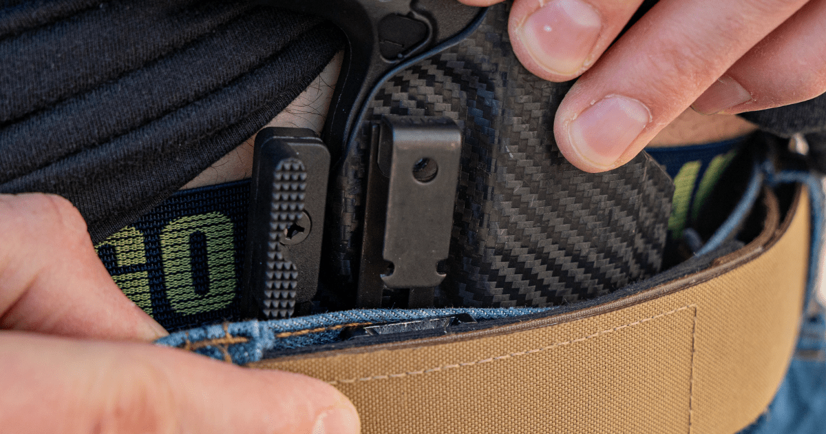 A man adjusting his IWB concealed carry holster using the Alias Receiver by NeoMag.