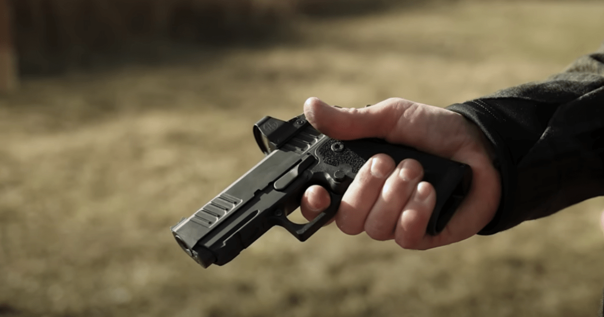 A man holding a Staccato CS against a grass background.