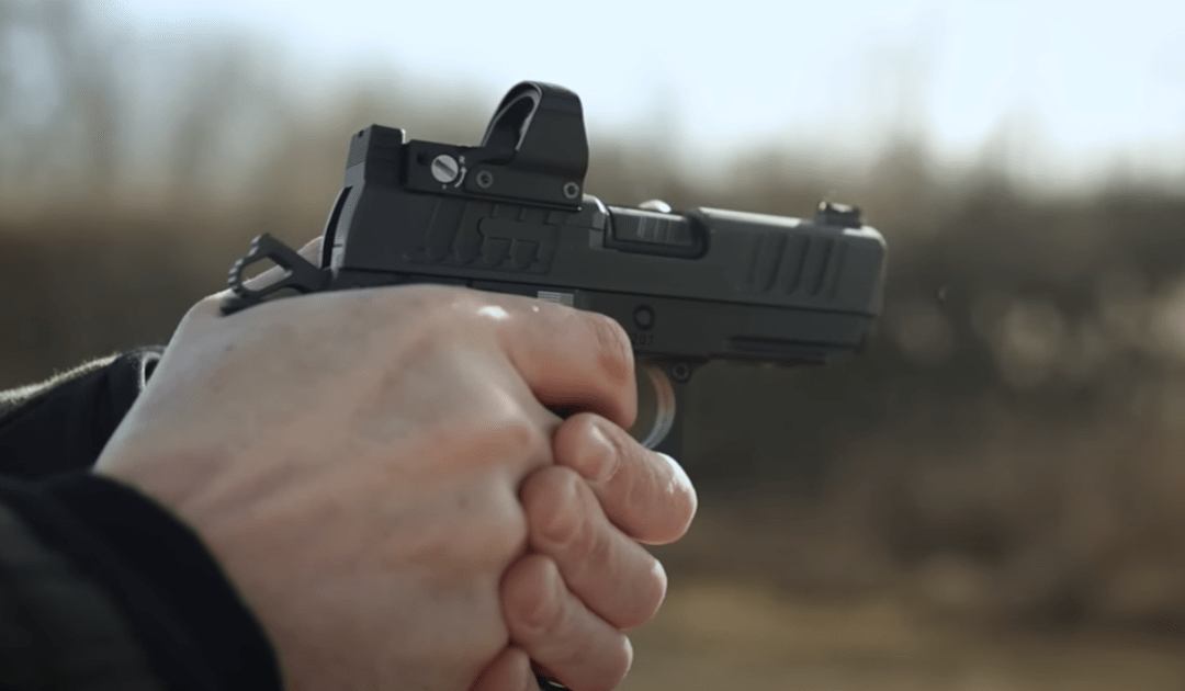 A man shooting a Staccato CS handgun.