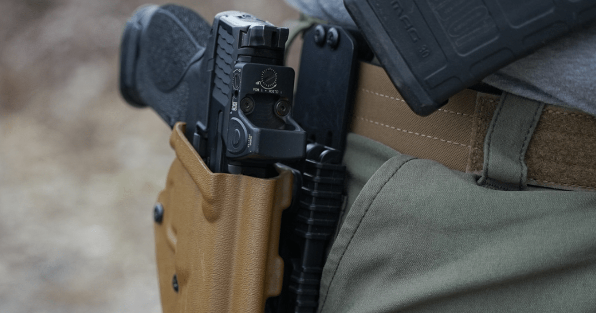 A man using the Alias Belt System to wear his holster outside the waistband.