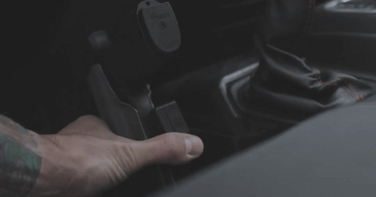 A person attaching his holster to his truck steering column with the Alias Hard Mount Receiver.