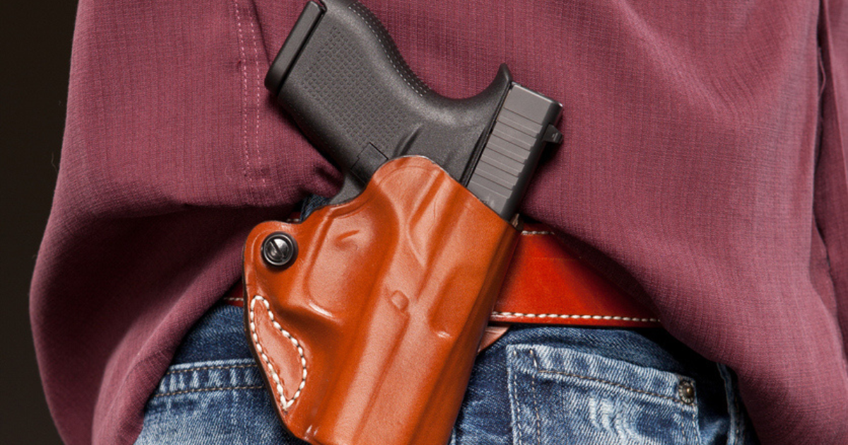 A man with his CCW firearm on an OWB holster on his hip.