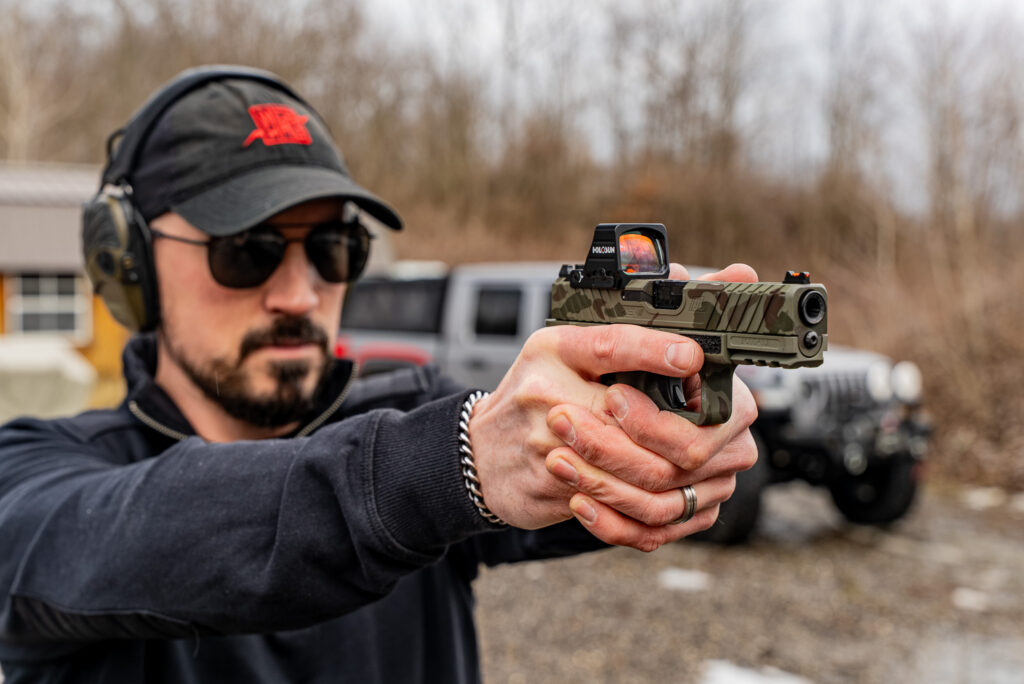 Graig shooting camo handgun with NeoMag hat on.