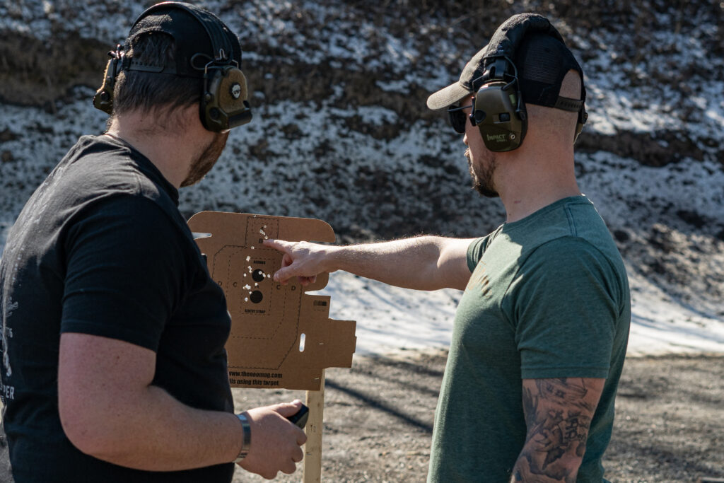 Two men looking at shooting target