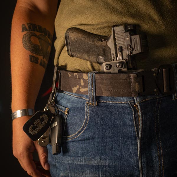 Black multicam alias belt on man with gun in waistband.
